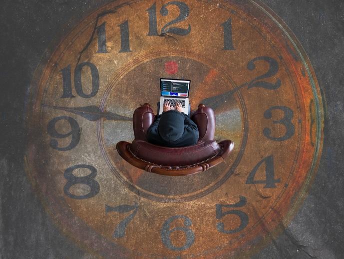 A person that’s using a computer on the clock-styled floor.